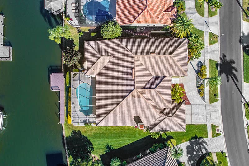 aerial drone photo of a waterfront real estate listing with a pool