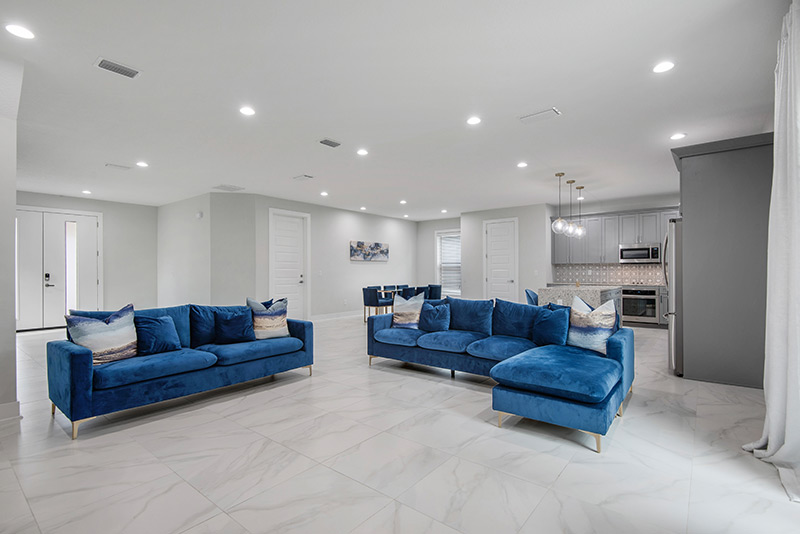 clean white living room with blue velvet sofas