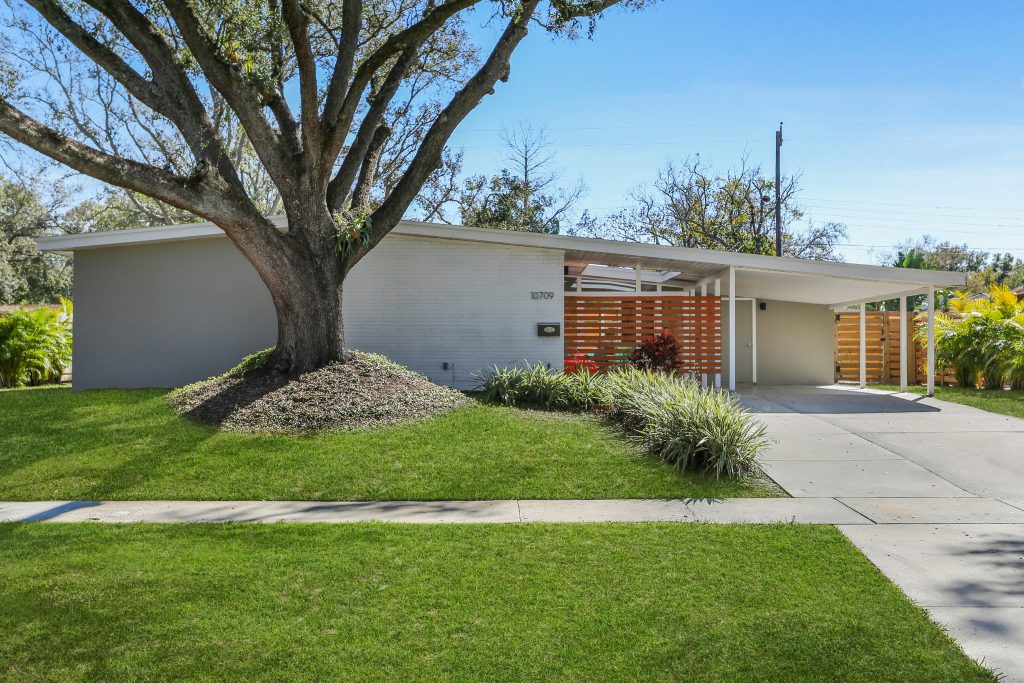 exterior front photo of a mid century modern old carrollwood home with grass replacement
