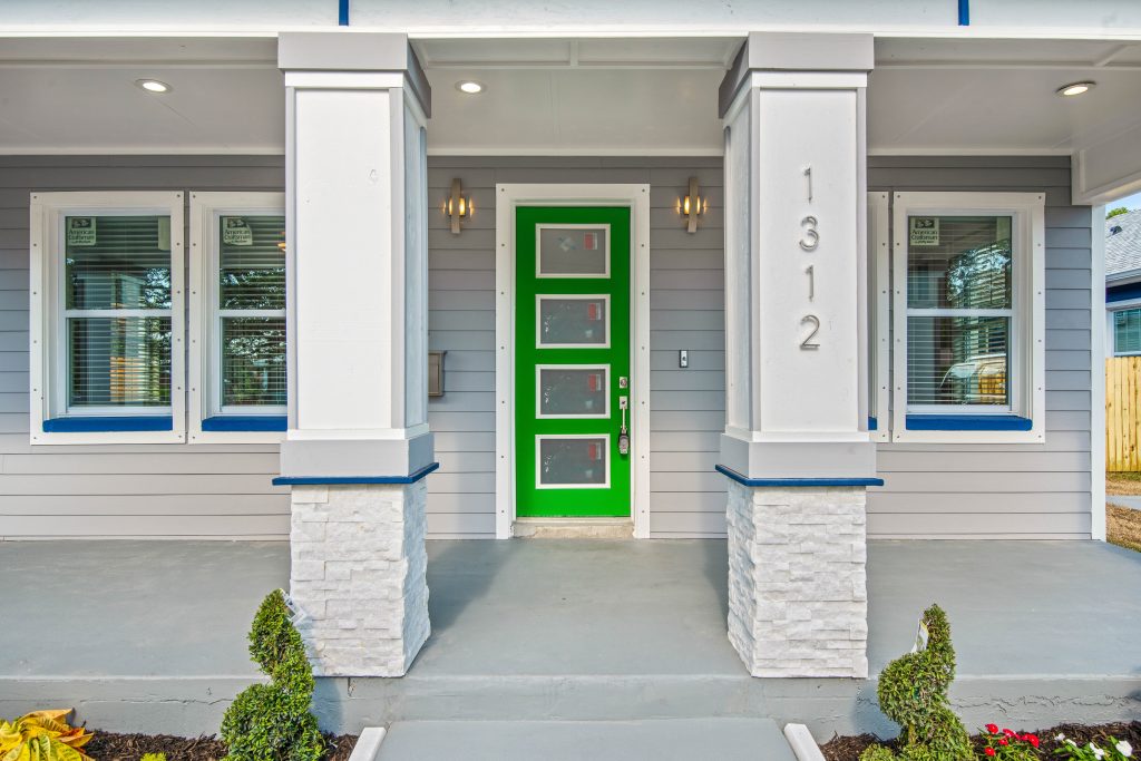photo of the front porch of a home with a green door