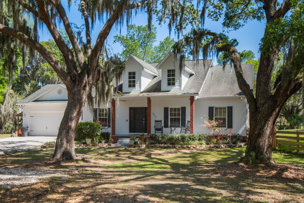 beautiful real estate listing with shady oak trees