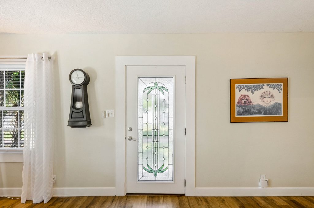 front door with a clock and painting