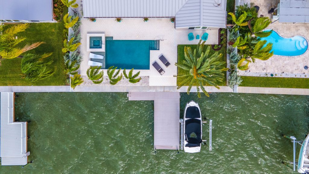 aerial drone photograph of a waterfront real estate listing with a pool